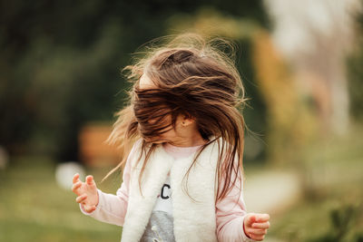 Girl looking away while standing outdoors