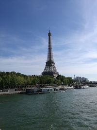 Eiffel tower by seine river against sky