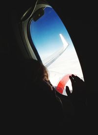 Close-up of silhouette airplane flying against sky