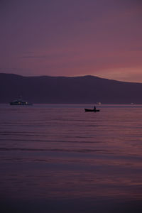 Silhouette boat sailing on sea against sky during sunset