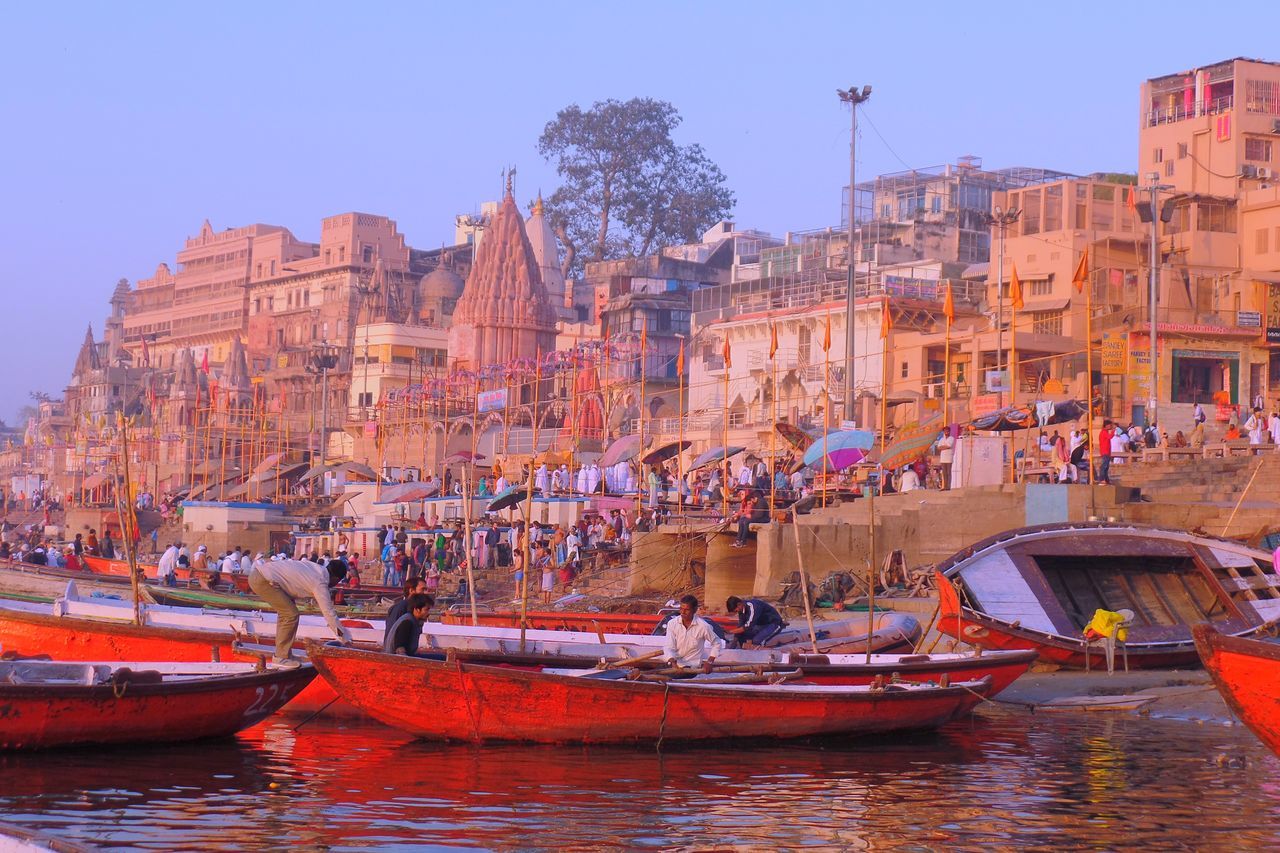 nautical vessel, transportation, mode of transport, boat, architecture, building exterior, built structure, waterfront, large group of people, moored, real people, outdoors, water, clear sky, day, men, nature, travel destinations, sky, sailing, gondola - traditional boat, people