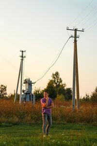 Epic photography of young brunette man, men in purple polo shirt standing outdoor on nature 