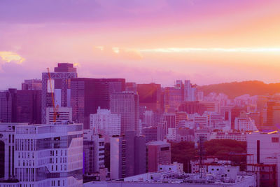 Buildings in city against sky during sunset