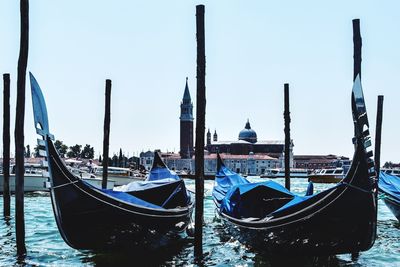 Boats moored in canal against clear sky