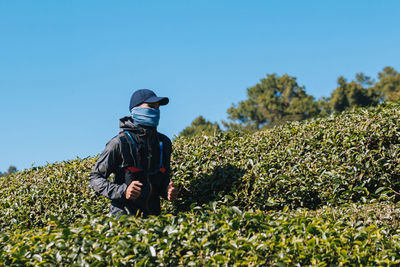 Rear view of man on field against clear sky