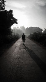 Rear view of man walking on road 