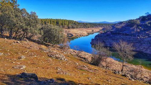 Scenic view of river against clear blue sky