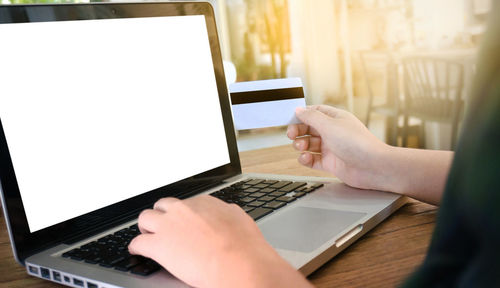 Midsection of woman using mobile phone on table