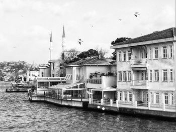 View of buildings by river against sky