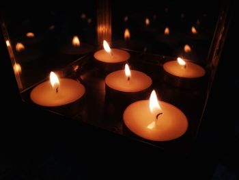 Close-up of lit candles in darkroom
