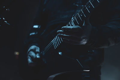 Close up of a mans hands playing an electric guitar 