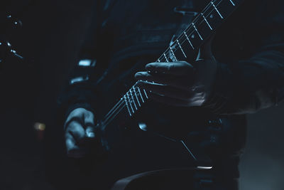 Midsection of man playing guitar