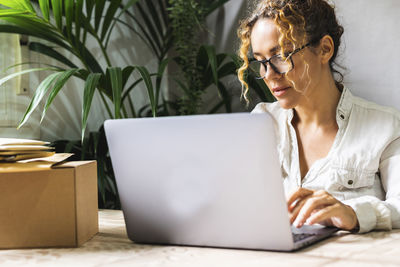 Young woman using laptop while sitting at home