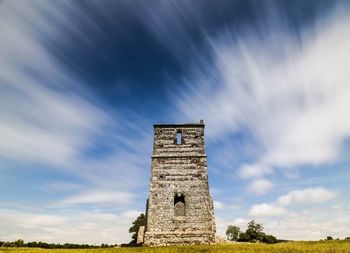 Low angle view of old building against cloudy sky