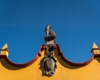 Low angle view of statue against clear blue sky