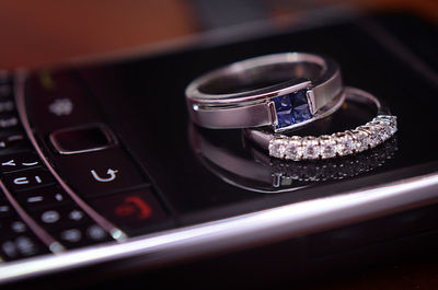 Close-up of wedding rings on cellphone