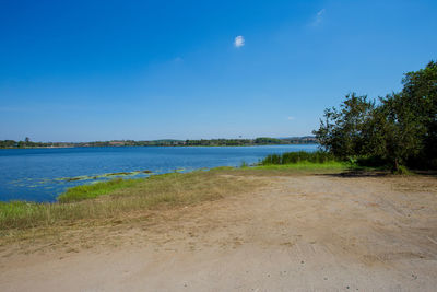 Scenic view of beach against blue sky