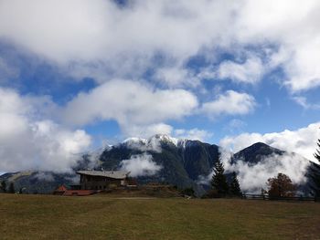 Scenic view of field by buildings against sky