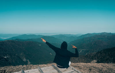 Man standing on mountain against clear sky