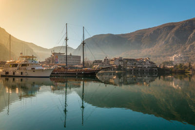 Sailboats moored in harbor against clear sky