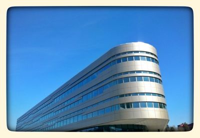 Low angle view of buildings against clear blue sky