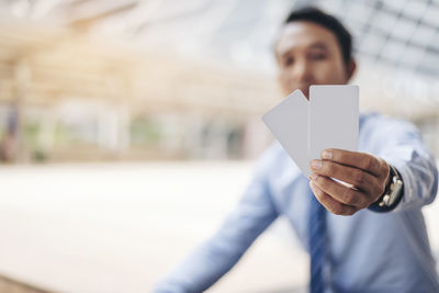 Businessman holding cards in city