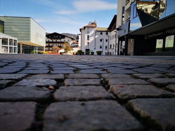 Surface level of footpath by buildings against sky