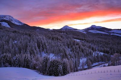 Scenic view of snow covered mountains against sky during sunset