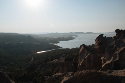 Scenic view of sea and mountains against clear sky