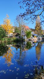 Scenic view of lake by buildings against sky
