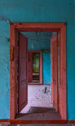 Abandoned double doors open doorway interior in blue-orange colors.