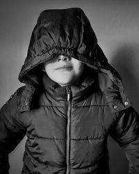 Full length portrait of boy standing against gray background