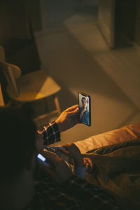 High angle view of sick man online consulting through video call on smart phone at home