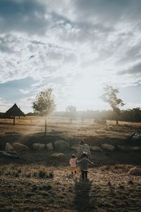 Rear view of family on field against sky