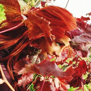 Portrait of young woman with red leaves