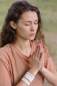 Close-up of young woman meditating outdoors