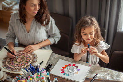 Mother and daughter drawing at home