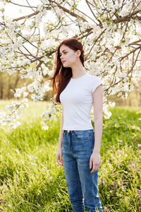 Young woman standing against trees