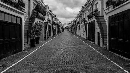 Empty walkway amidst buildings