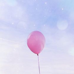 Low angle view of pink balloons against sky