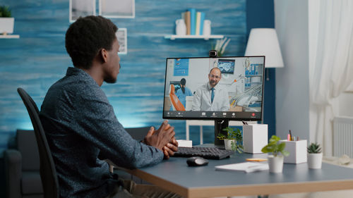 Side view of man using laptop at home