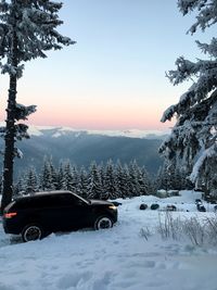 Car on snow covered mountain against sky