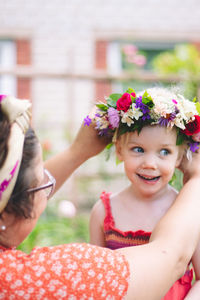 Portrait of smiling girl with flowers on plant