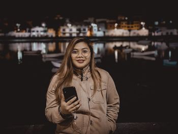 Portrait of a woman using smart phone at night