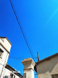 Low angle view of buildings against clear blue sky