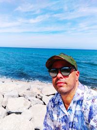 Portrait of young man in sea against sky