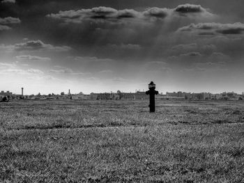 Fire hydrant on grassy field against sky