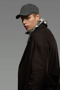 Young man looking away against white background