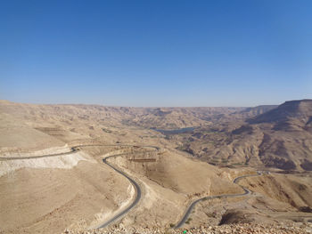 Scenic view of desert against clear blue sky