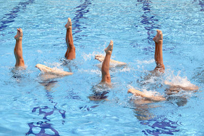 Low section of people swimming in pool